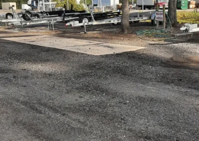 A boat and trailer are parked in the lot of Matthews Boat and RV Storage facility.